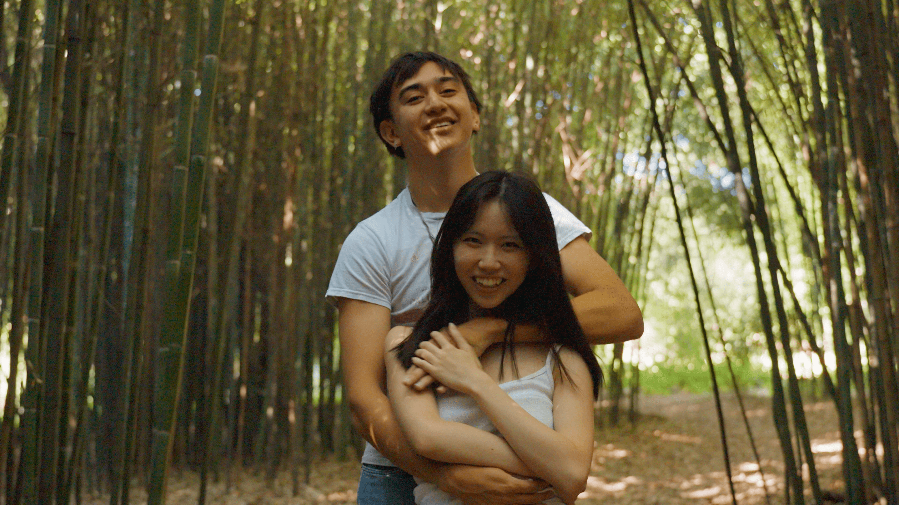 Guy and girl hugging and smiling at camera